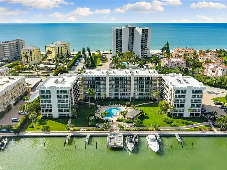 Aerial view of Gulf-front condominium buildings with a pool, marina and the Gulf of Mexico behind, Naples, Florida